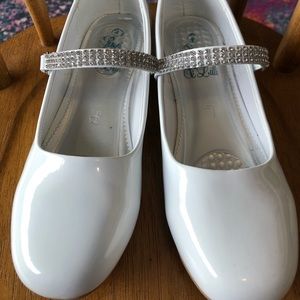 White patent shoes with rhinestone strap.